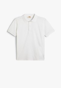 Camisa polo blanca de manga corta hecha de algodón, con un collar clásico, tapeta de dos botones y una textura suave. Sin patrones ni acentos.