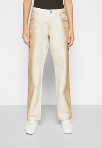 Jeans femininos bege com um degradê castanho desbotado nas coxas, corte reto, cinco bolsos e detalhes em metal.
