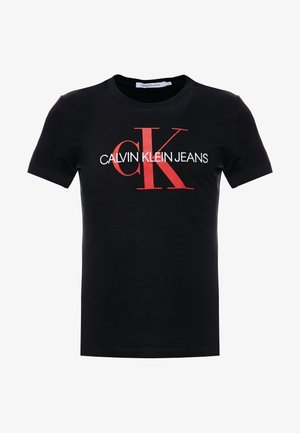 Zwart T-shirt met korte mouwen en een groot rood "cK"-logo en witte tekst "CALVIN KLEIN JEANS" gecentreerd op de voorkant.