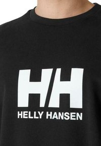 Černé bavlněné tričko s velkým bílým logem "HH" a textem "HELLEY HANSEN" umístěným na střední části přední části, kulatým výstřihem a krátkými rukávy.