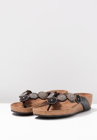Sandali neri con suola in sughero, caratterizzati da una fascia decorata con perline a forma di fiore in tonalità argento e oro. Morbido materiale della soletta in marrone.