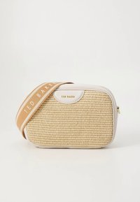 Beige gewebte Handtasche mit weißem Lederobermaterial, ausgestattet mit einem beigefarbenen Riemen mit "TED BAKER"-Etikett und einem goldenen Logo-Akzent auf der Vorderseite.