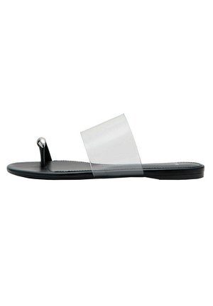 Sandale plate noire avec une large bride transparente et une boucle pour orteil avec une pointe métallique argentée.