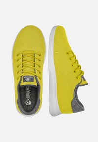 Gelbe Mesh-Sneaker mit grauen Akzenten, weißen Sohlen und traditioneller Schnürung. Strukturierte Oberseite für Atmungsaktivität und Komfort.