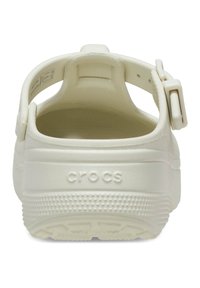 Witte Crocs met een achterband, met een gestructureerde buitenkant, rond ontwerp en een reliëflogo op de hiel. Gestructureerde zool voor grip.
