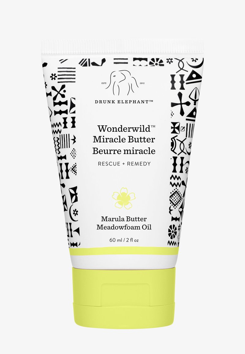 White tube with black geometric patterns, yellow accents, and a flip-top lid. Text includes "Wonderwild Miracle Butter" and ingredients listed.