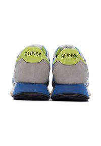 Sneaker da uomo con tomaia in suede grigio, accenti blu e linguette di tallone verde lime. Presentano una suola ammortizzata e una suola esterna in gomma con texture.