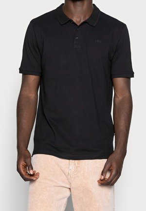 Camisa polo negra con cuello, tapeta de tres botones y mangas cortas. Fabricada en una tela suave con un sutil logo de la marca en el pecho.