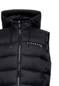 Gilet imbottito nero con cappuccio, dotato di zip frontale, cordino regolabile e dettaglio del logo sul petto e sulle cinghie laterali.