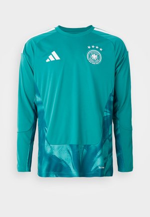 Grünes Sporttrikot mit langen Ärmeln und rundem Halsausschnitt. Es hat weiße Akzente, ein rundes Emblem und ein verlaufendes, strukturiertes Muster am unteren Rand.