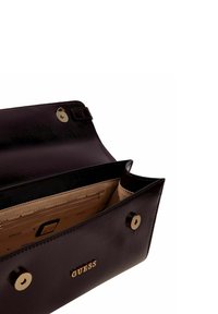 Portefeuille en cuir marron foncé avec une texture lisse, doté d'un logo doré et de fermetures à pression. L'intérieur comprend des compartments beiges et des emplacements pour cartes.