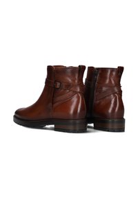 Bruine leren enkelboots met een gladde afwerking, een zijrits en een decoratieve gespband rond de enkel. Stevige rubberen zool.
