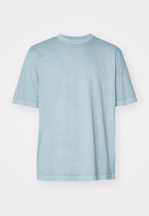 T-shirt bleu clair à manches courtes en tissu doux, avec un col rond et un logo discret sur la poitrine, doté de coutures renforcées.