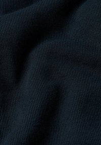 Tessuto in maglia blu navy con una texture a costine, che presenta morbide pieghe e grinze che creano profondità e movimento nel materiale.