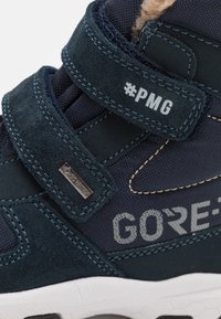 Calzado de textil y ante en azul marino con dos correas de velcro, que cuenta con una suela de goma y el logotipo de GORE-TEX en gris. Detalle #PMG incluido.