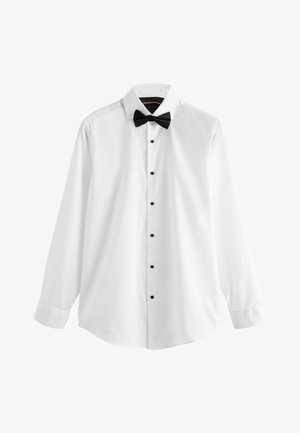 Camicia bianca a maniche lunghe con bottoni neri e papillon nero, mostrata su uno sfondo bianco semplice.