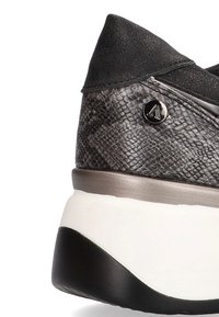 Zapatilla en cuero de serpiente sintético negro y gris con un upper texturizado, acento de logo metálico y una suela gruesa en blanco y negro.