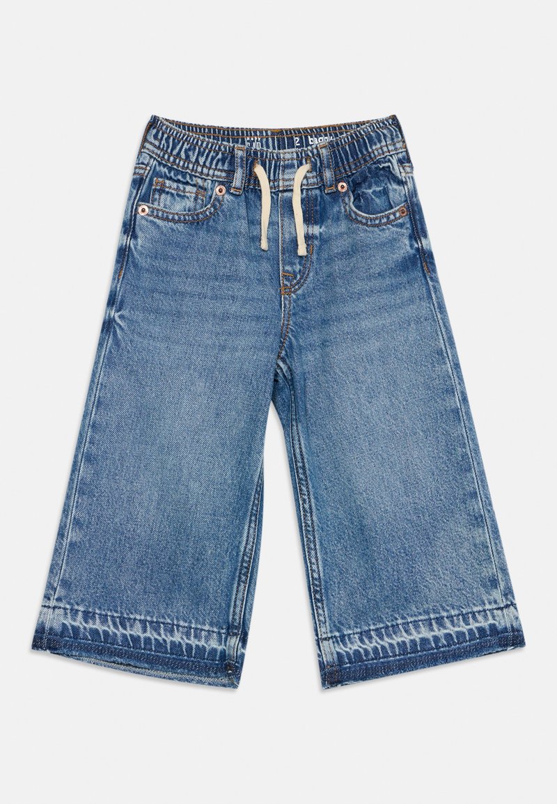 Short large en denim bleu avec taille élastique et cordon blanc, comprenant des poches avant et des détails délavés aux ourlets.