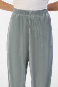 Pantalons côtelés vert clair, avec une taille élastique et une texture douce. Présente des rayures verticales pour plus de détails et une coupe décontractée.