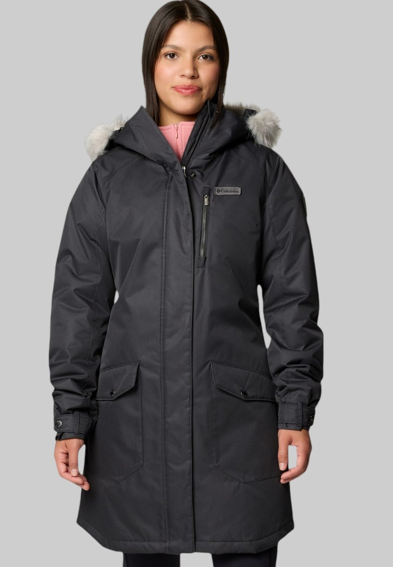 Schwarze Parka mit Kunstfellkapuze, Reißverschluss vorne, zwei großen Fronttaschen und verstellbaren Bündchen. Glattes, wetterfestes Außenmaterial.