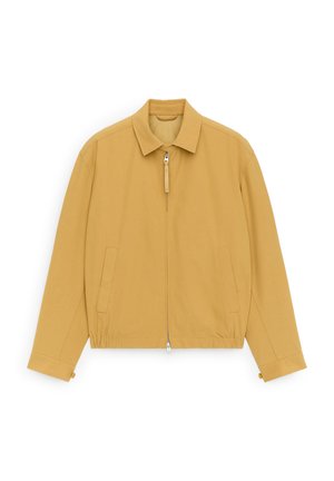 Lichtbruine jas met rits en kraag, lange mouwen, voorzakken en een elastische tailleband, plat neergelegd op een witte achtergrond.