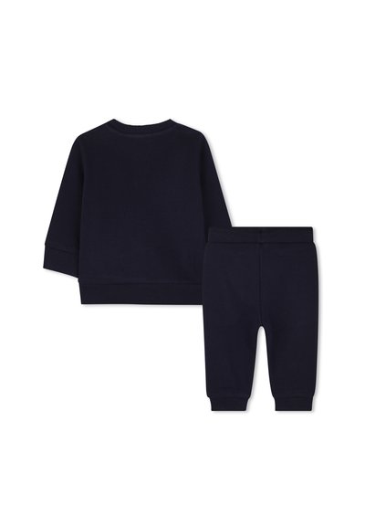 Donkerblauwe katoenen trainingspakset omvat een long sleeve top met ronde hals en bijpassende taps toelopende broek met elastische tailleband en boorden.