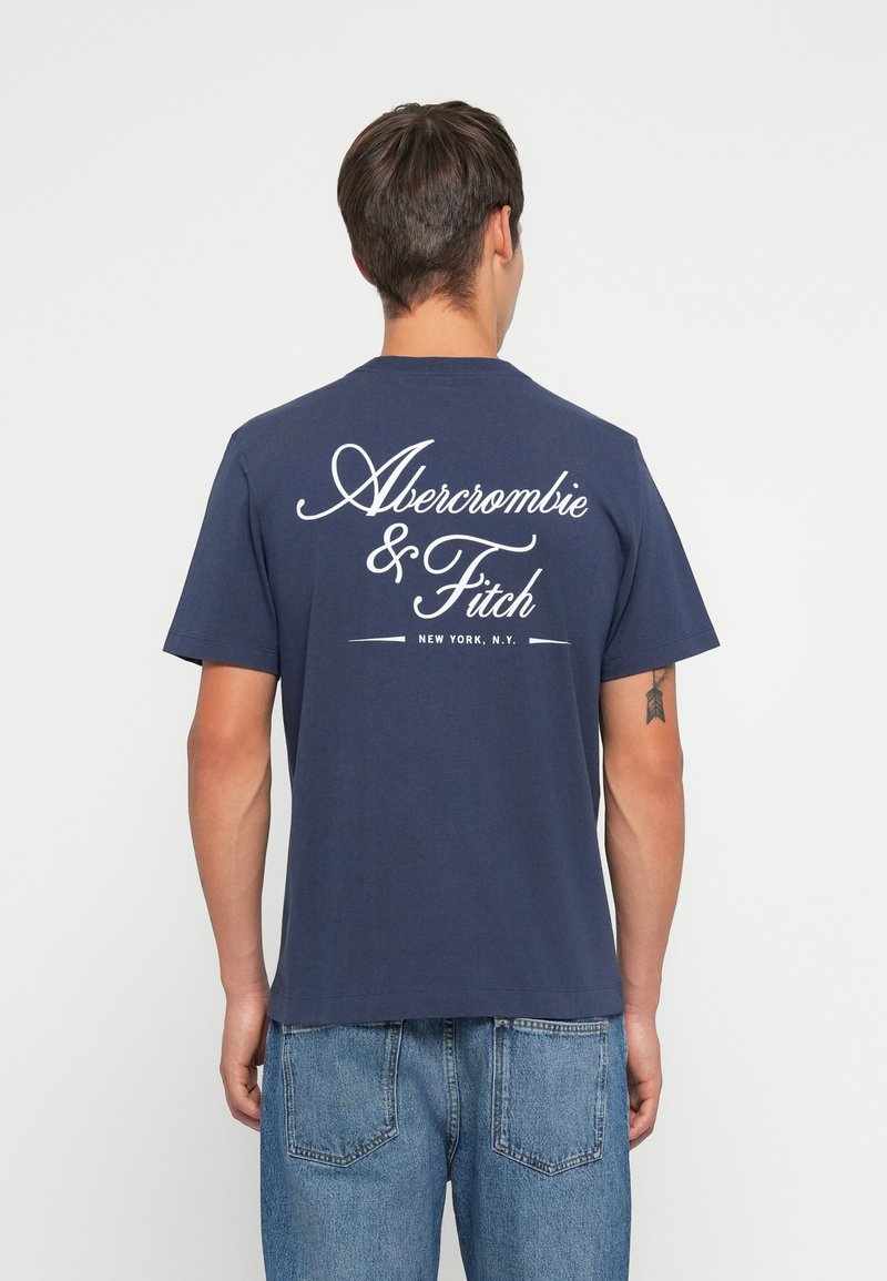 Námořnicko modré bavlněné tričko s bílým nápisem "Abercrombie & Fitch" a umístěním "New York, N.Y." na zadní straně, krátký rukáv, volný střih.