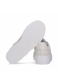 Sneakers bianchi in pelle con dettagli texturizzati, suole in gomma con un motivo a spina di pesce e design minimalista.