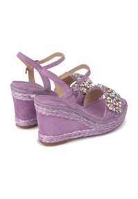 Sandali wedge in suede viola con cinturino decorato, soletta in giute intrecciata e suola in gomma. Dotati di cinturino alla caviglia regolabile.