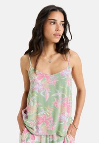 Light green floral tank top featuring pink and white tropical flower patterns, thin straps, and a relaxed fit with side pockets.
