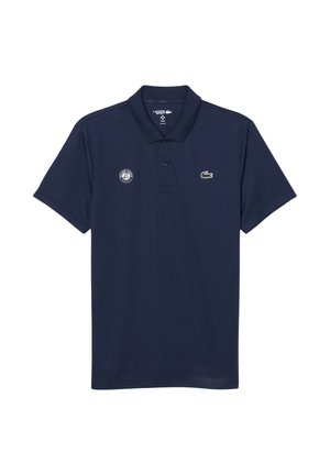 Marineblaue Lacoste Sport Poloshirt mit zwei Knöpfen, mit Roland-Garros-Logo auf der linken Brust und grünem Krokodil-Logo auf der rechten Brust.