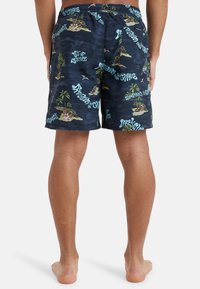 Navy swim shorts featuring a tropical pattern with palm trees and island scenes, elastic waistband, and side pockets.