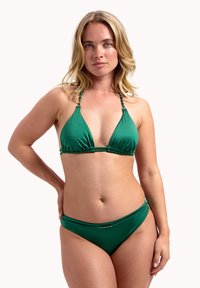 Zelená bikiny souprava s trojúhelníkovým topem s popruhy zdobenými korálky a jednoduchým, nízkým spodním dílem. Hladká, pružná textura látky.