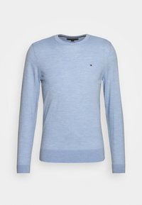 Pull bleu clair en tissu doux, avec un col rond et des manches longues. Comprend un petit logo près de la zone gauche de la poitrine.