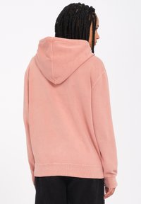 Pink hooded sweatshirt made of soft fabric, featuring a relaxed fit, ribbed cuffs and hem, and a kangaroo pocket design.