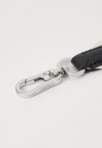 Cinturino in pelle nera trapuntata con una chiusura in metallo argentato, caratterizzato da incisioni "KARL LAGERFELD" e una superficie liscia con una finitura lucida.