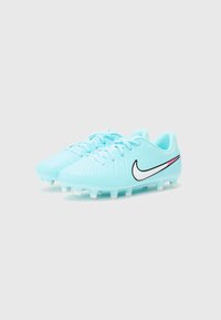 Vaaleansiniset jalkapallokengät, joissa on teksturoitu pinta, musta Nike-logo ja vaaleanpunainen yksityiskohta. Varustettu muotoilluilla valkoisilla nappuloilla, jotka tarjoavat pitoa nurmikolla.