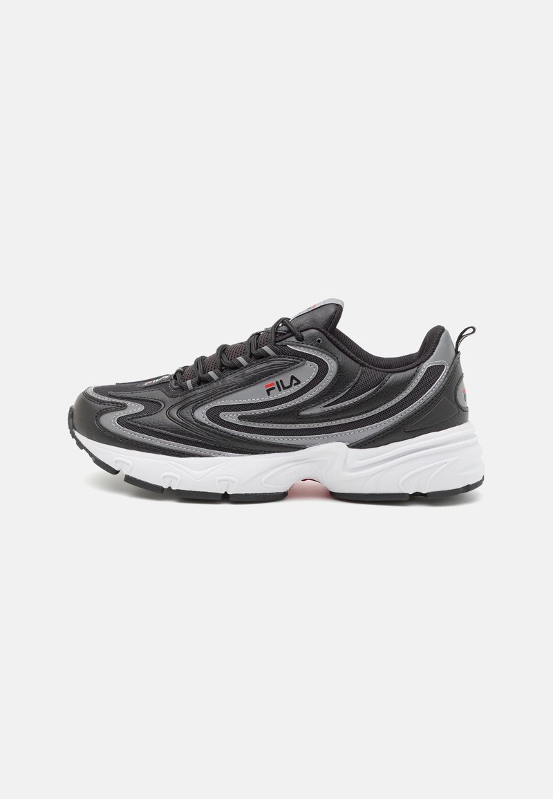 Baskets FILA noires et grises avec une semelle blanche épaisse et des lignes de design ondulées, lacées, vue de côté sur un fond clair.