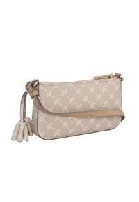 Borsa in pelle beige con motivo a foglia bianca, chiusura con zip e tracolla removibile. Presenta un dettaglio a nappina su un lato. Texture liscia.