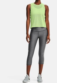 Limegrön nät-tanktop med en avslappnad passform, kombinerad med grå capribyxor med en mjuk textur och stretch. Grå sportskor ingår.