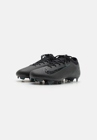 Mustat jalkapallositeet, joissa on teksturoitu pinta, ja joissa on näkyvä musta kimalteleva Nike-logo sekä matala profiili. Kuusi nastaa pitoa varten.
