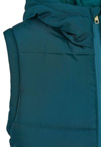 Prošívaná modrozelená vesta s kapucí, s výkonným zipem, hladkým textilním povrchem a viditelnými detailem šití.