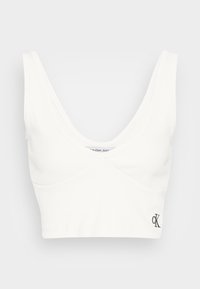 Biała, prążkowana bralette z dekoltem w kształcie łódki, szerokimi ramiączkami oraz subtelnym logo w dolnym rogu. Miękka, elastyczna tkanina.