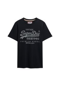 Camiseta de algodón negra con un logo impreso en gris que dice "Vintage SuperDry" con acentos y texto en varios idiomas. Mangas cortas.