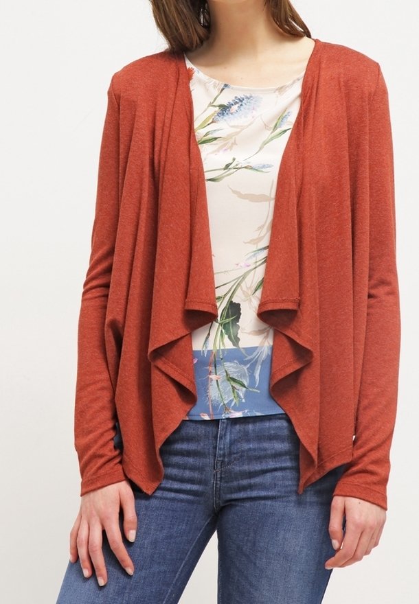 Rdzawoczerwony kardigan z otwartym przodem, długimi rękawami i luźnym fasonem, zestawiony z t-shirtem w kwiatowy wzór i niebieskimi akcentami.