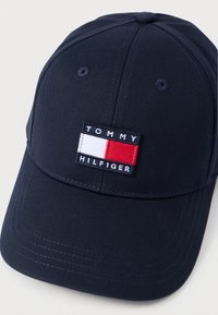 Καπέλο μπέιζμπολ σε ναυτικό μπλε χρώμα με καμπύλη γείσο και κεντημένο λογότυπο με κόκκινο, άσπρο και μπλε. Κατασκευασμένο από ανθεκτικό ύφασμα με ραμμένες λεπτομέρειες.