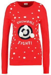 Pull rouge en tricot avec des pois blancs, un motif de cible circulaire bleu marine avec trois pompons, et le texte « COMBAT DE BOULES DE NEIGE ! » en blanc.