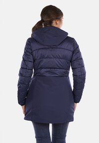Giacca puffer blu marino con cappuccio, dotata di sezioni trapuntate, vita aderente e una texture liscia e slanciata. Design di lunghezza media fino alla coscia.