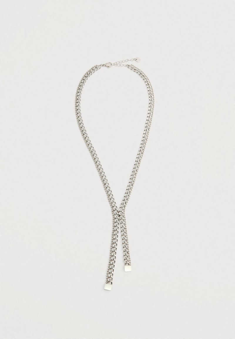 Hopeaketju hopeanvärisellä sävyllä, jossa on kaksoistrantteja, ja neliömäiset metallikoristeet päissä sekä turvallinen lukitus.