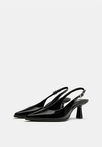 Pantofi cu toc slingback din piele lacuită neagră, cu vârf ascuțit, cu o curea îngustă și toc bloc de înălțime medie. Textură netedă.